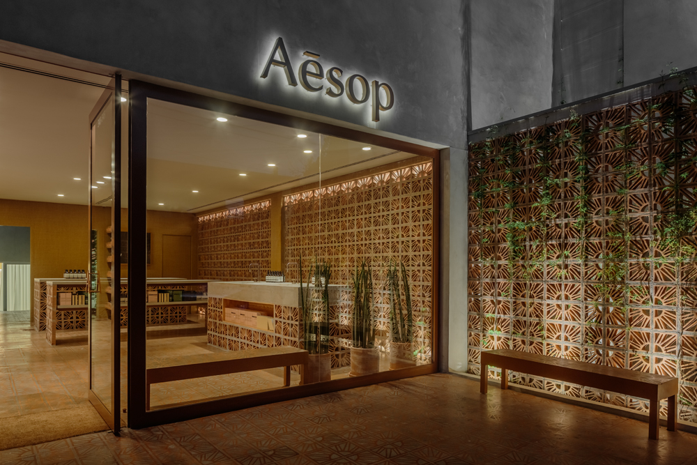 Les designers brésiliens Fernando et Humberto Campana signent la dernière boutique Aesop à São Paulo. La brique Cobogó, une brique ajourée beaucoup utilisée dans la construction en Amérique du Sud pour favoriser la ventilation et l’ombre, est le matériau phare de cette nouvelle adresse. Autre originalité : L’architecture se prolonge à l’extérieur sous la forme d’une petite place publique, appelée à devenir un lieu d’échanges dans le quartier.