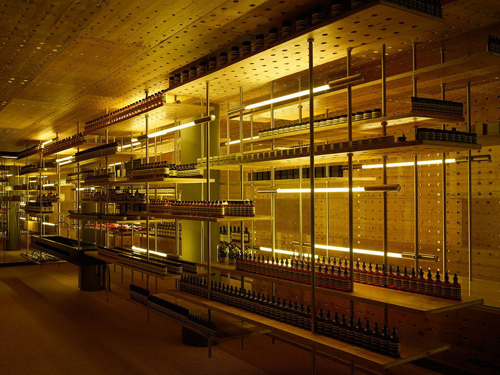 Rodney Eggleston a imaginé un environnement industriel pour la première boutique Aesop à Zurich (Oberdorfstrasse). L’espace étroit s’articule autour d’une étagère suspendue fabriquée à l’aide de matériaux recyclés des travaux publics, dont les planches jaunes d’échafaudages récupérées dans la ville.