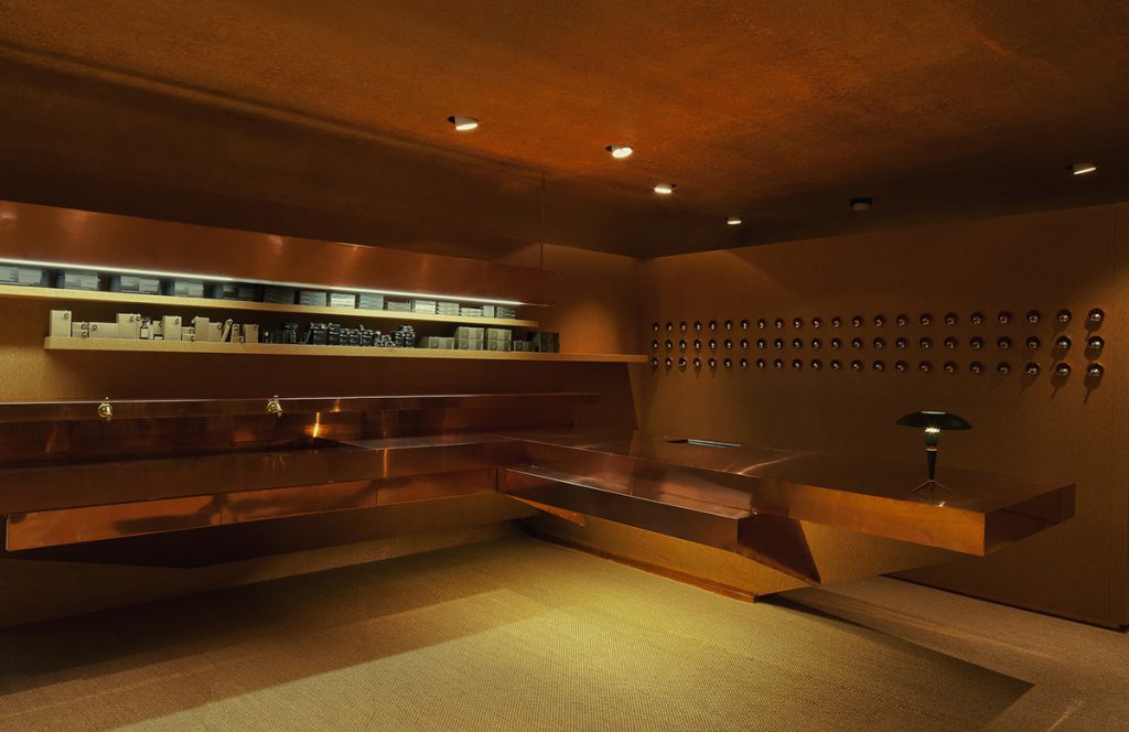 C’est un peu le fantasme du bunker alpin que l’architecte australien Rodney Eggleston, fondateur de March Studio, a cherché à exprimer à Genève. Parée de cuivre, la boutique de la Rue de la Fontaine se veut un clin d’œil au commerce international autant que la planque imaginaire et ultra chic d’agents secrets.